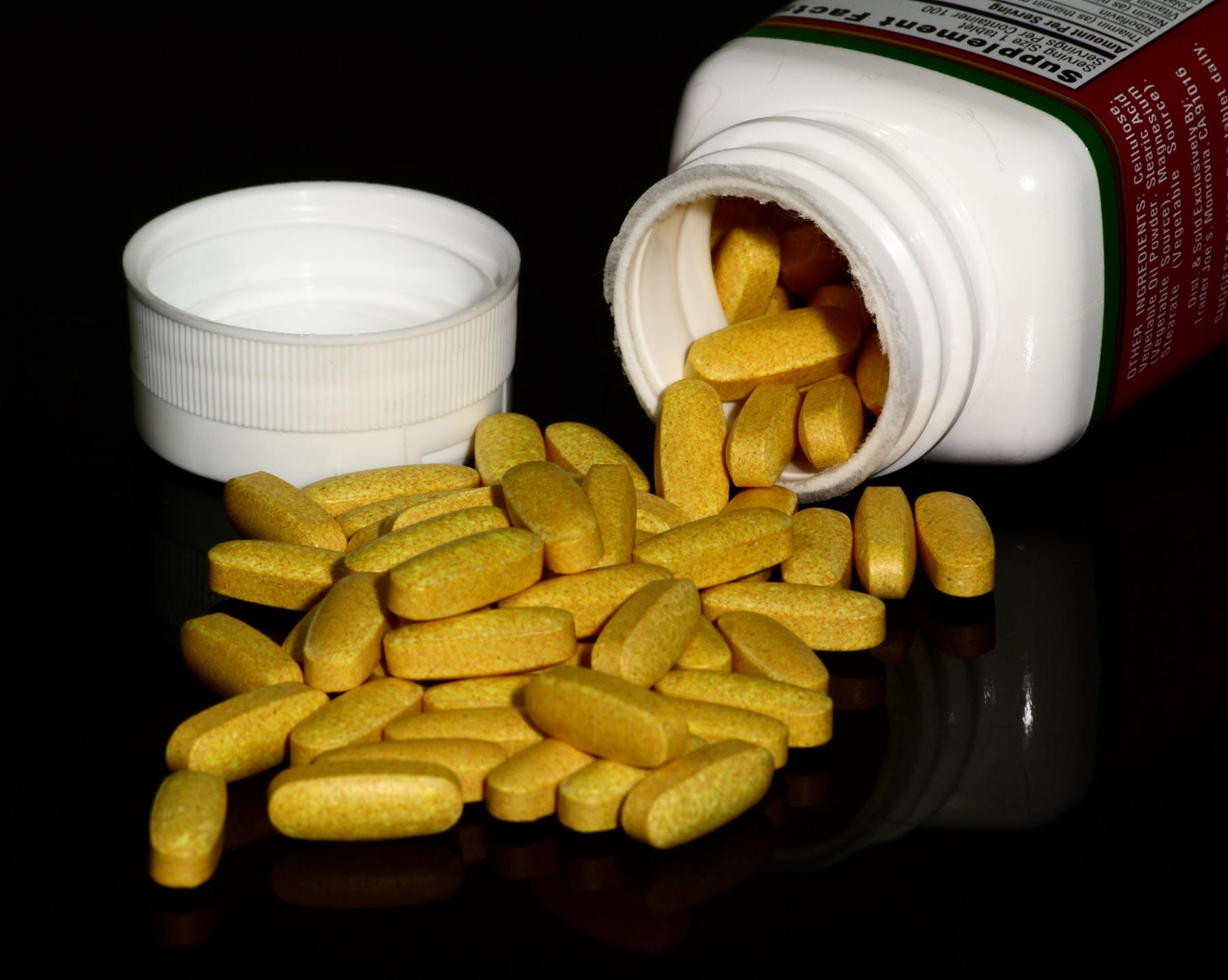 a bottle of pills with a bottle of pills and a bottle of pills - File:B vitamin supplement tablets.j